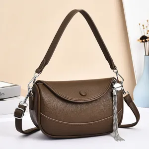 Brown leather shoulder bag detailed view, elegant curved flap crossbody handbag with chic tassel.