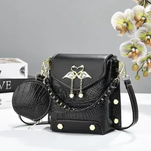 Sac bandoulière noir motif crocodile avec porte-monnaie rond et fermoir perle de cygne élégant.