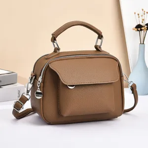 Brown soft leather women crossbody bag detail, multi-compartment design with metal hardware.