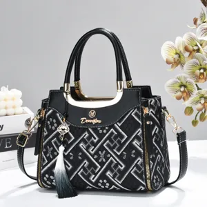 Detailed shot of the stylish black embroidered handbag featuring intricate geometric patterns.
