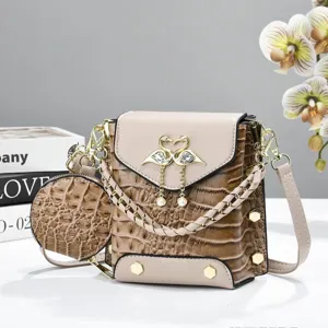 Détail petit sac bandoulière, sac carré motif croco avec joli décor de cygne et porte-monnaie.