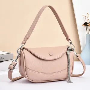Pink leather crossbody bag detail, stylish women shoulder bag with tassel charm and adjustable strap.