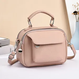 Stylish pink leather crossbody bag with top handle, multi-compartment casual shoulder bag.