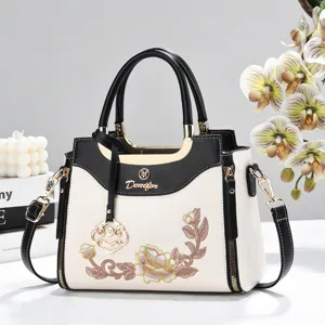 Elegant Chinese-style embroidered women handbag, black and white color block shoulder bag detail.