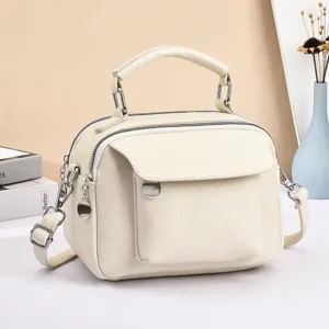 Detail view of the stylish cream soft leather crossbody bag with multi-compartments.