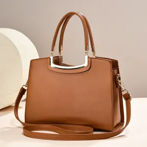 Elegant brown leather top-handle shoulder bag with chic metal hardware for women commuting.