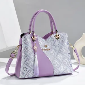 Detailed view of fashionable purple embroidered women shoulder handbag with elegant tassel charm.
