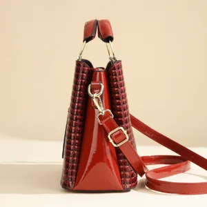 Red patent leather shoulder bag with chic crocodile texture and gold hardware details.