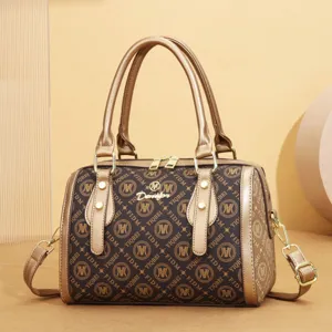 Detailed view of women fashion retro monogram shoulder bag with metallic golden top handles.