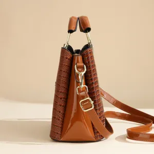 Detailed view of the brown PU leather bucket shoulder bag showing texture and golden hardware.