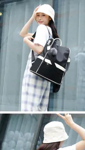 Close-up view of casual black oxford cloth backpack with stylish contrast white trim and charm.