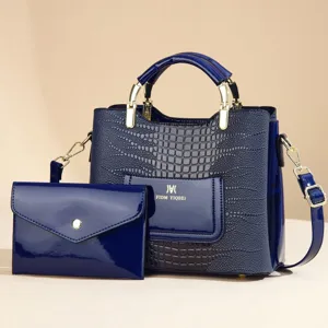Dark blue patent leather handbag with crocodile texture and matching clutch pouch detail.