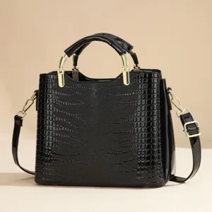 Elegant black patent leather crocodile texture handbag with gold hardware detail and strap.