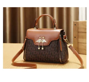 Vintage monogram handtas voor dames, elegante bruine schoudertas met zwaan hanger voor stijl.