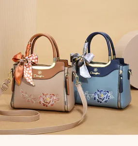 Detailed view of the peony embroidery, metal hardware, and chic silk scarf on the handbag.