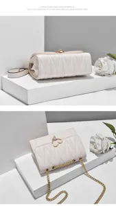 Stylish white quilted crossbody bag for women with chic gold heart lock and metal chain strap.