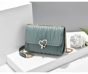 Green quilted small square shoulder bag with gold chain and heart lock for women daily use.