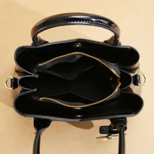 Dettaglio interno della borsa tote da donna in pelle verniciata nera con zip.