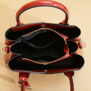 Dettaglio interno borsa shopper in pelle verniciata rossa con scomparti e zip sicura.