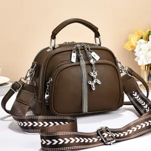 Brown leather women's shoulder bag with multi-zipper compartments and wide patterned strap.