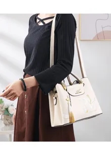 Elegant women's shoulder handbag with delicate floral embroidery, tassel charm and premium finish.