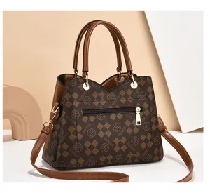 Bolso de mujer a cuadros marrones con asas superiores y correa para uso diario.
