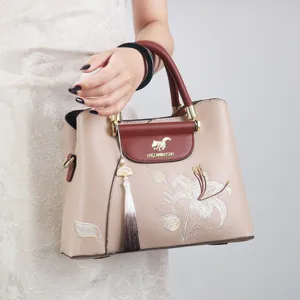 Elegant retro embroidered handbag for women, featuring floral patterns and tassel pendant.