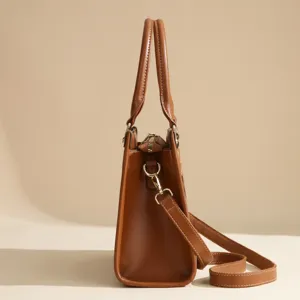 Side profile detail view showcasing the brown leather tote bag structure and metal hooks.