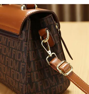 Vintage monogram schoudertas voor dames, stijlvolle bruine crossbody tas met metalen hardware.