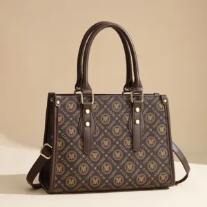 Brown monogram tote bag detail showing leather handles, gold tone hardware and large interior.