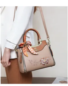 Elegant embroidered handbag detail view, featuring floral pattern and stylish silk scarf.