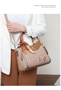 Detailed view of the elegant embroidered handbag with silk scarf and metallic hardware accents.
