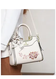 Detail view of the elegant peony embroidered handbag with chic silk scarf decoration and gold hardware.