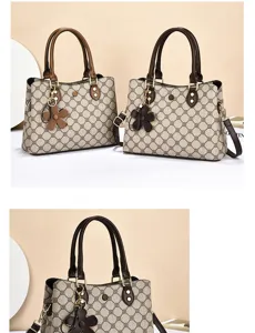 Detail view of women's vintage monogram shoulder bag with floral pendant and double top handles.