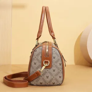 Detailed view of the vintage monogram pillow handbag featuring brown leather handles.