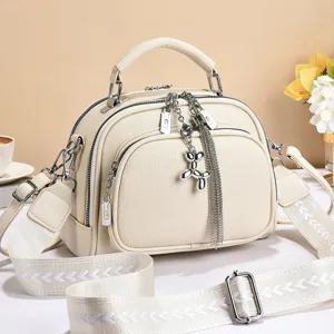 Stylish women crossbody bag with wide strap and cute balloon dog pendant, cream white PU leather.