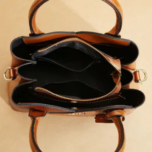Borsa a mano marrone in pelle verniciata con scomparti multipli e manici eleganti.