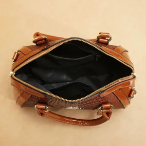 Détail de l'intérieur d'un sac à main en cuir verni avec une grande capacité et une fermeture.