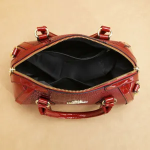 Vue détaillée de l'compartiment intérieur du sac à main rouge avec détails dorés et fermeture.