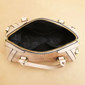Vue détaillée de l'intérieur du sac à main pour femme en cuir verni, texture croco et zips dorés.