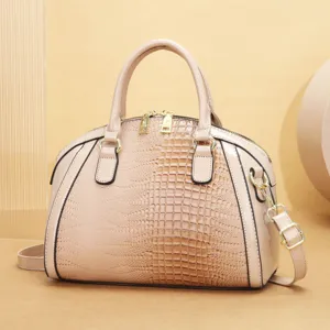 Vue détaillée de l'élégant sac à main dôme beige en cuir verni gaufré façon croco.