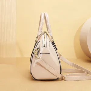 Vue détaillée du sac à main élégant en cuir vernis nude montrant le profil latéral et la quincaillerie.