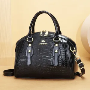 Sac à main noir en cuir verni gaufré croco avec poignées supérieures et bandoulière réglable.