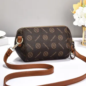 Detailed view of the brown monogram cylinder crossbody bag with stylish leather strap.
