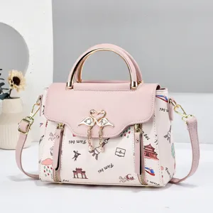 Chic pink and white women's handbag with top handle, shoulder strap, and cute printed pattern.