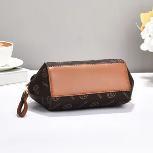 Detail shot of the brown monogram barrel handbag, featuring PU leather patchwork and zipper.