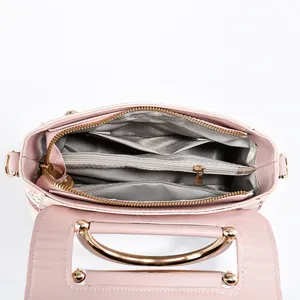 Detailed interior view of a pink women handbag with multiple compartments and zippers.