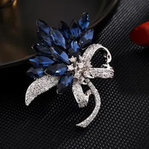 Close-up detail shot of exquisite blue crystal rhinestone bow flower brooch, elegant jewelry.