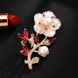 Elegant flower brooch with shimmering pearls, red crystal stones and sparkling cubic zirconia.