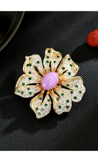 Elegante Pfingstrosen-Brosche mit funkelnden Strasssteinen und violettem Mittelstein.